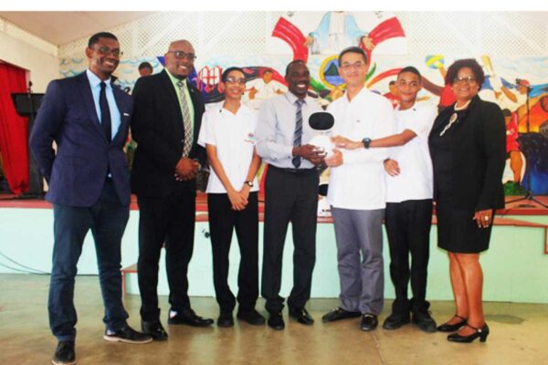 H.E. Peter Chia-Yen Chen, Taiwan’s Ambassador to Saint Lucia, third from right, presents one of the educational robots to Mr. Neal Fontenelle, Principal of St. Mary’s College, fourth from right, at Thursday’s handover ceremony. Also pictured are Mr. Anthony Bousquet, Chairman of the Board of St. Mary’s College, far left, Hon. Shawn Edward, Minister for Education, Sustainable Development, Innovation, Science, Technology and Vocational Training, second from left, Hon. Dr. Pauline Antoine-Prospere, Parliamentary Secretary in the Ministry of Education, far right, and two students.