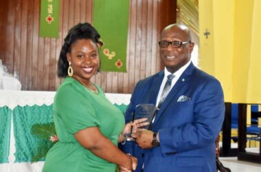 The VOICE Publishing Company representative Tricia Jn Baptiste accepting an award from Infrastructure Minister Stephenson King
