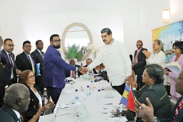 Venezuelan President Nicolas Maduro, right, and Guyanese President Irfaan Ali shake hands ahead of talks over Essequibo