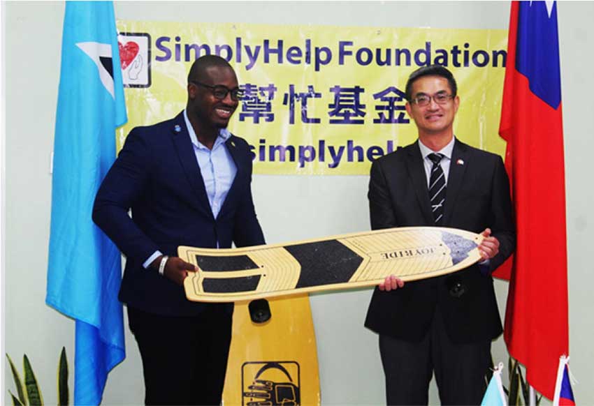 H.E. Peter Chia-Yen Chen, Taiwan’s Ambassador to Saint Lucia, joins Hon. Kenson Casimir, Minister for Youth Development and Sports, display one of the skateboards that formed part of the donation from SimplyHelp Foundation.