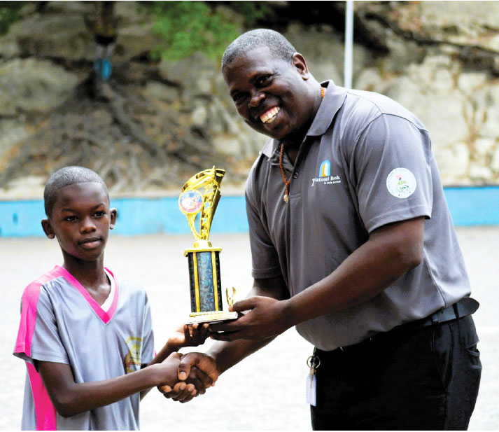 Sports Director Clivus Jules presents Daveril Albert with his prize trophy