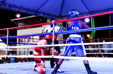 A Saint Lucian boxer (blue) knocks down his opponent