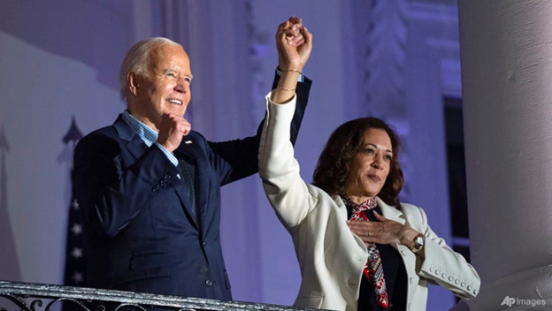 President Joe Biden raises the hand of Vice President Kamala Harris after viewing the Independence Day fireworks display over the National Mall from the balcony of the White House, on Jul 4, 2024, in Washington. (AP Photo/Evan Vucci)