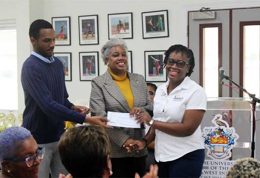  (left-right): Mr. Joshua Bishop, Alumni Assistant, Mrs. Sandra Griffith-Carrington, Campus Alumni Office and Coordinator, ‘Preparing Today for Tomorrow’s Challenges’, The UWI Global Campus receiving the donation from Ms. Stacia Brathwaite, Public Relations Coordinator, Sandals Resort & Spa.