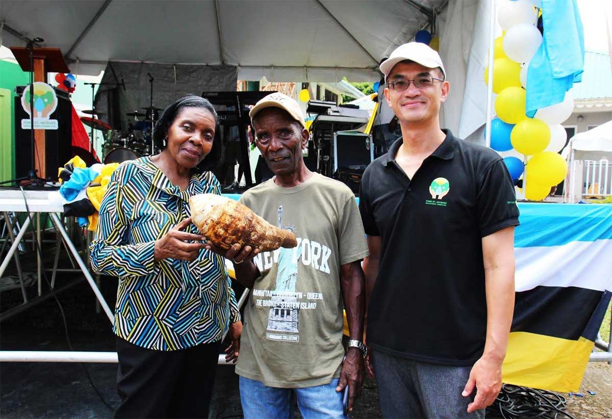 H.E. Peter Chia-Yen Chen, Taiwan’s Ambassador to Saint Lucia, and Hon.Emma Hippolyte, Minister for Commerce, Manufacturing, Business Development, Cooperatives and Consumer Affairs, and Parliamentary Representative for Soufriere/Fond St. Jacques, pose with the winner of the largest dasheen competition at the Dasheen Festival on Saturday, September 28, 2024.