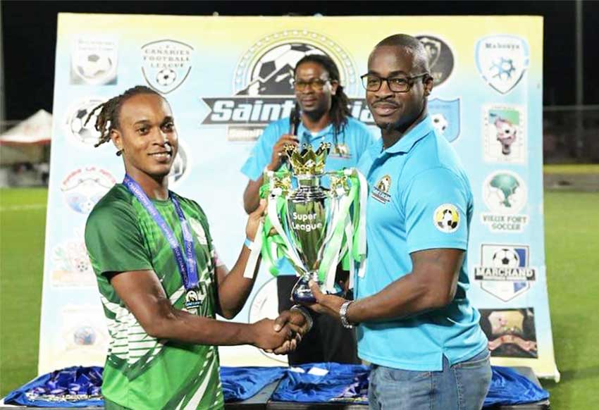 Vieux Fort South captain Kimlan Mason receives Super League trophy from Sports Minister Kenson Casimir