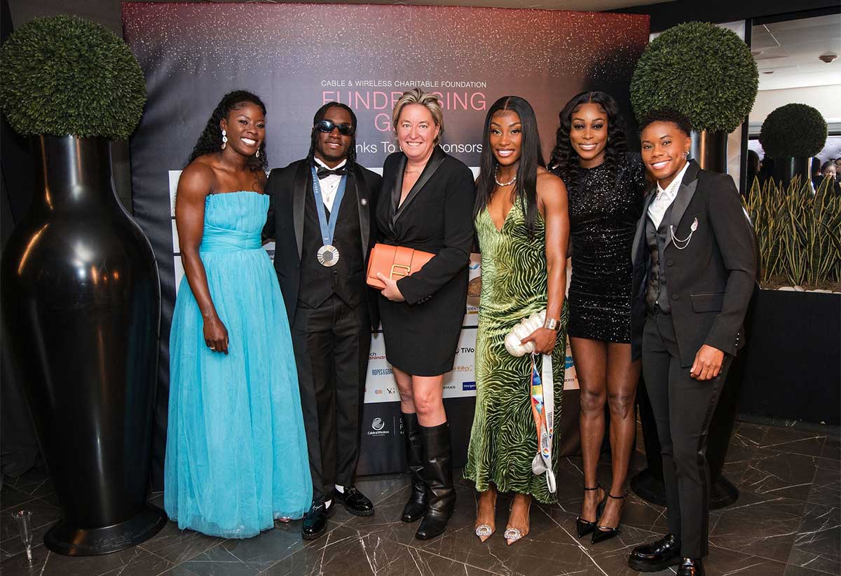 Inge Smidts (third left), Chief Executive Officer, C&W Communications, strikes a pose with athlete-ambassadors (from left) Shericka Jackson, Wayne Pinnock, Charokee Young, Elaine Thompson-Herah and Devynne Charlton.