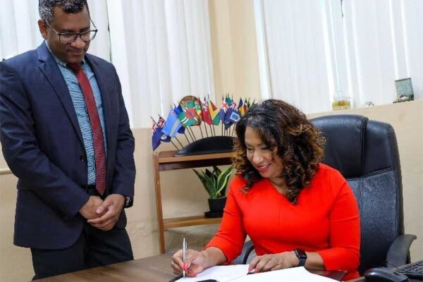 Dr Lisa Indar, CARPHA Ad Interim Executive Director signs the MOU between CARPHA and TEPHINET to strengthen public health and disease surveillance systems management in the Caribbean, while Dr Mark Sami, CARPHA Director Corporate Services looks on.