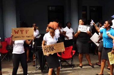 1st National Bank staffers protest outside the bank’s compound on upper Bridge Street…