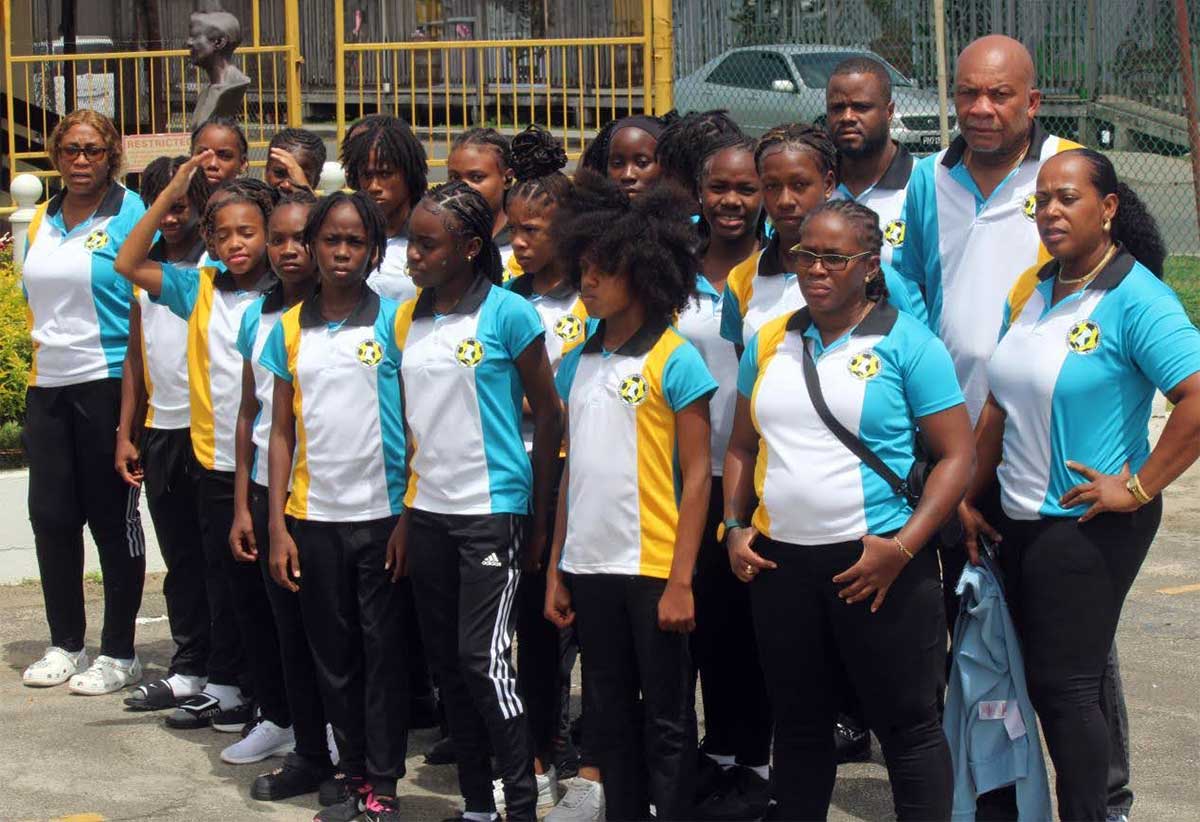 The team with managers and coaches at the Sir George F. L .Charles Airport Wednesday