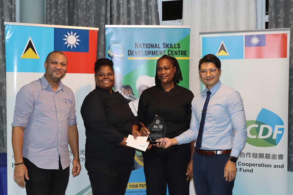 Mr. Barry Paul, Deputy General Manager of the National Skills Development Centre (NSDC), at far left, and Mr. Daniel Lee, Chief of the Taiwan Technical Mission (TTM) in Saint Lucia, at far right, present the winners -- Lillian George and Esther Girard, winners of Friday’s competition – with their trophy and monetary prize.