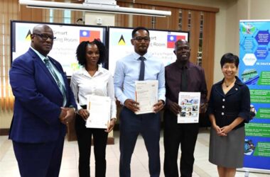 H.E. Nicole Su, Taiwan’s Ambassador to Saint Lucia, and Hon. Stephenson King, Senior Minister for the Ministry of Public Service, Transport, Information and Utilities Regulations, pose with the three participants in the ISO/IEC 27001 workshop (Credit: TTM)