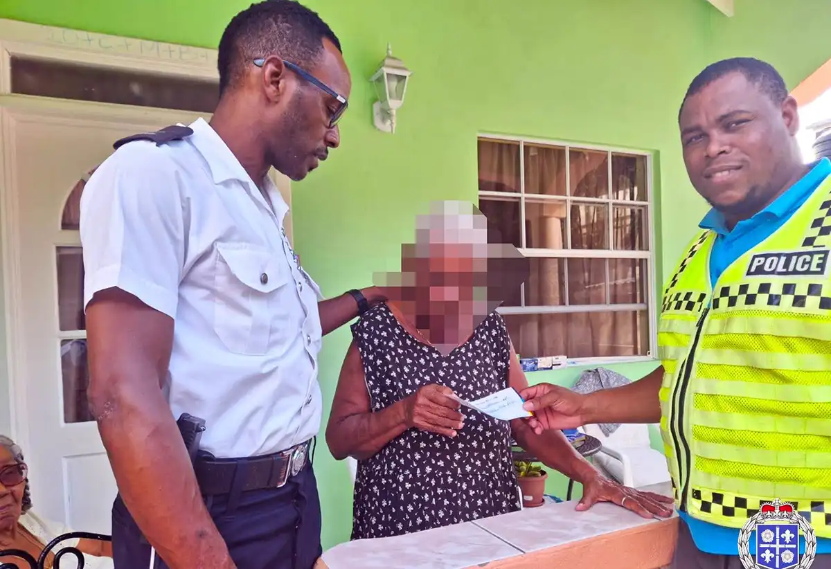 Canaries police officers present vouchers to elderly women in the community [Photo credit: RSLPF] 