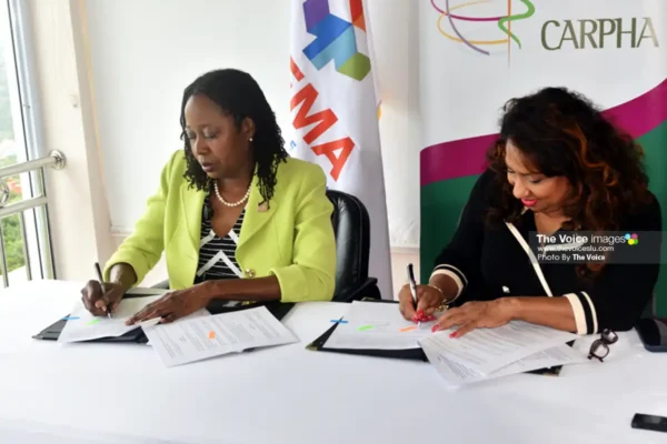 Strengthening disaster preparedness and emergency response across the Caribbean, Elizabeth Riley, CDEMA Executive Director (left), and Dr. Lisa Indar, CARPHA Executive Director, sign the agreement for continued partnership.