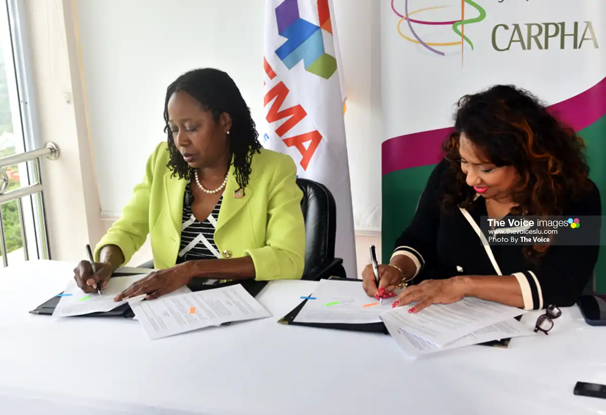 Strengthening disaster preparedness and emergency response across the Caribbean, Elizabeth Riley, CDEMA Executive Director (left), and Dr. Lisa Indar, CARPHA Executive Director, sign the agreement for continued partnership.