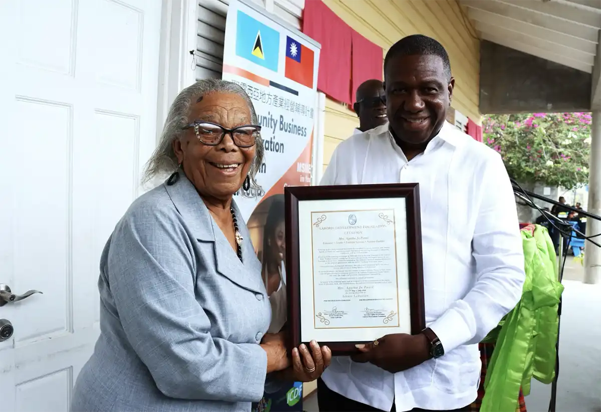 Mrs. Agatha Jn. Panel, former school principal and senator, receives her citation from Hon. Alva Baptiste, Minister for External Affairs, International Trade, Civil Aviation and Diaspora Affairs, and Parliamentary Representative for Laborie/Augier.