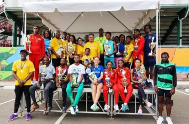 Sports Minister Kenson Casimir (in the background) alongside Caricom and government officials and runners at the event [Photo credit: CARICOM]