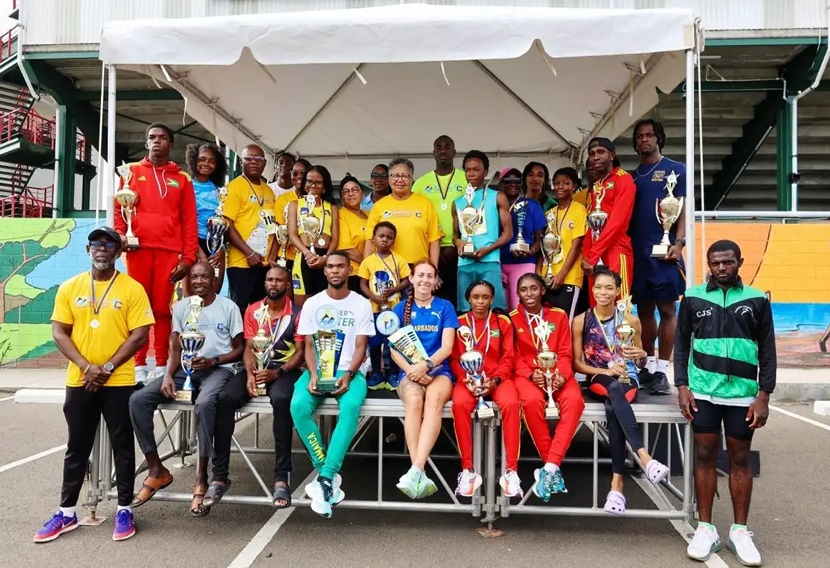Sports Minister Kenson Casimir (in the background) alongside Caricom and government officials and runners at the event [Photo credit: CARICOM] 