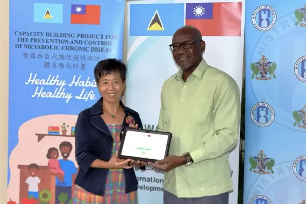 Ambassador Nicole Su hands over the tablet computers to Health Minister Hon. Moses Jn. Baptiste
