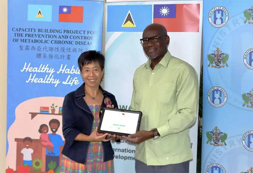 Ambassador Nicole Su hands over the tablet computers to Health Minister Hon. Moses Jn. Baptiste