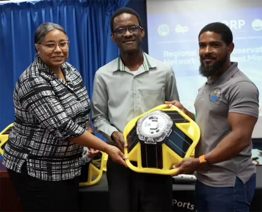 Courtney Forde (right) CIMH Technical Research Officer, handing over the buoys to Deputy Permanent Secretary George Melchoir (center) and Director of Meteorological Services Vigil Saltibus (right). (Photo - contributed)