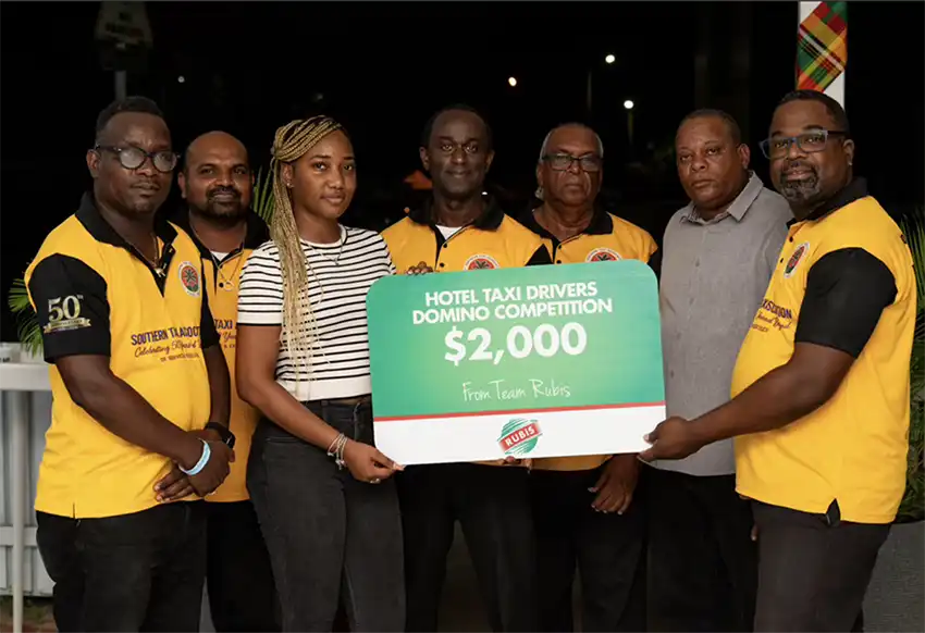 Tamika Celestin, Assistant Accounts Executive, RUBIS, presents cheque to members of the Hotel Taxi Association. (Photo – Contributed)